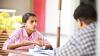 Woman sitting at a table talking to a man opposite her