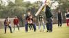 Group of young people playing cricket