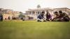 4 students sit talking outside a University in Pakistan 
