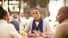 Two men and a woman sitting at a table talking in South Africa