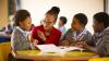Female teacher guiding happy boys and girls in South Africa