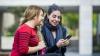 Two young women chatting and looking at a mobile phone