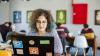 Woman sitting at desk in a shared space using a laptop 