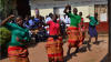 Students in local dress dance to greet their visitors