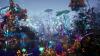 The image is a videogame still showing a scene of bioluminescent plants and organisms by a riverbed.