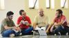 Group of young men sitting on the floor, talking and laughing