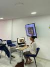 Woman sitting at a desk teaching. 
