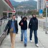 Three people walking along a street in Hong Kong.